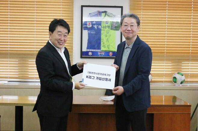 안병모 천안시축구단장(왼쪽)이 조연상 한국프로축구연맹 사무총장에게 K리그 가입신청서를 제출하고 있다. 
[천안시축구단 제공. 재판매 및 DB 금지]
