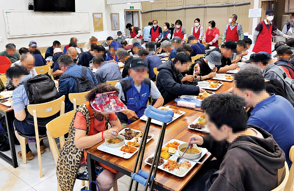 수혜자들이 28일 함께하는교회가 운영하는 경기도 수원역광장 앞 무료급식소 ‘정 나눔터’에서 식사하고 있다.