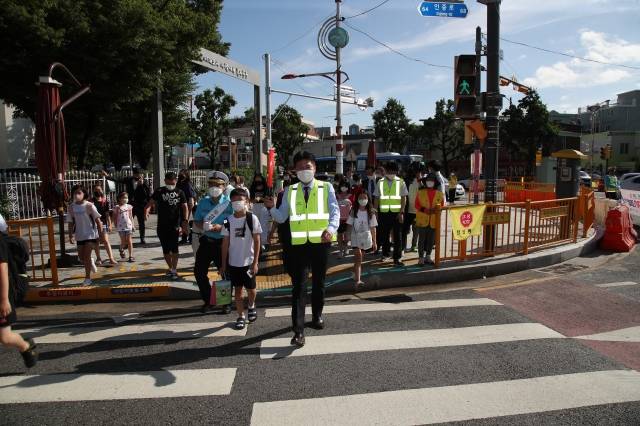 김정헌 인천 중구청장이 1일 취임식에 앞서 횡단보도에서 길을 건너는 초등학생들의 안전 도우미 역할을 하고 있다. 인천 중구 제공