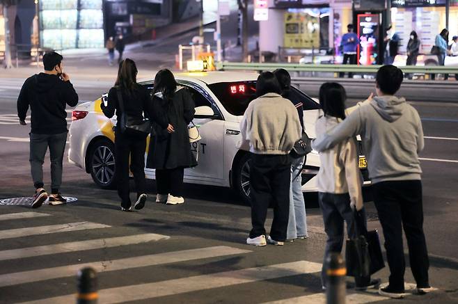서울 강남역 인근에서 여러 시민이 빈 택시를 향해 모여들고 있다. [연합]