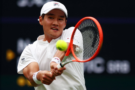 Kwon Soon-woo returns the ball to Serbia's Novak Djokovic during their men's singles tennis match on the first day of Wimbledon at the Centre Court of the All England Lawn Tennis and Croquet Club in London on Monday. [AFP/YONHAP]