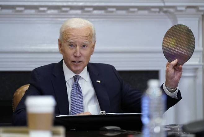 지난해 4월 조 바이든 미국 대통령이 백악관에서 열린 ‘반도체 화상회의’에 직접 참석해 반도체 웨이퍼를 들어 보이며 발언하고 있다. [AP]
