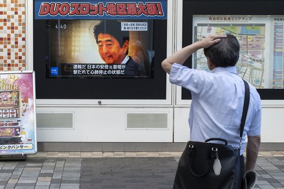 8일 오후 일본 도쿄에서 한 시민이 TV에서 흘러나오는 아베 신조 전 총리 피습 관련 뉴스를 보고 있다. [AFP=연합뉴스]