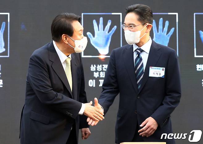 윤석열 대통령이 25일 용산 대통령실 청사 앞 잔디마당에서 열린 2022 대한민국 중소기업인대회에서 핸드프린팅을 마친 이재용 삼성전자 부회장과 악수하고 있다. (대통령실사진기자단) 2022.5.25/뉴스1 © News1 오대일 기자