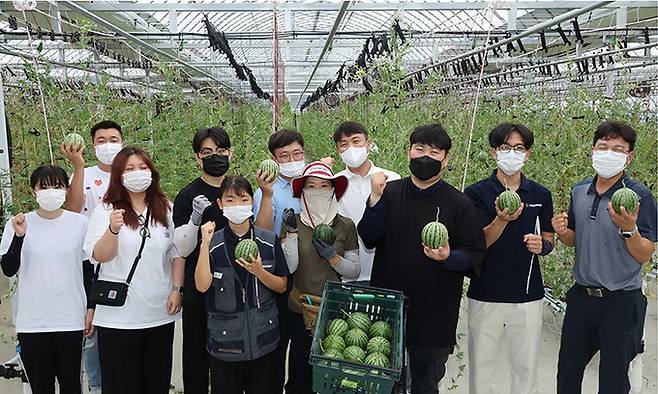 스마트팜 실습에 참여한 예비창업자들이 애플수박 농장 앞에서 파이팅을 외치고 있다.