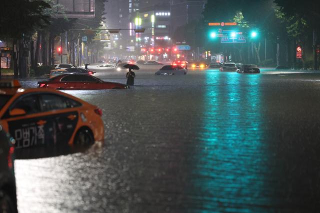 8일 밤 서울 강남구 대치역 인근 도로가 물에 잠기면서 차량과 보행자들이 통행에 어려움을 겪고 있다. 연합뉴스
