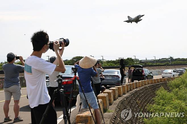 (로이터=연합뉴스) 지난 7일 대만 신주 공군기지에 착륙하는 대만 군용기를 시민들이 촬영하는 모습. 2022.8.8.