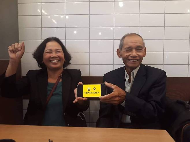 9일 국가배상소송에서 진술하기 위해 방한한 응우옌티탄(왼쪽), 응우옌득쩌이(오른쪽)가 변론 전 “승소”란 푯말을 들고 웃고 있다. 한베평화재단 제공