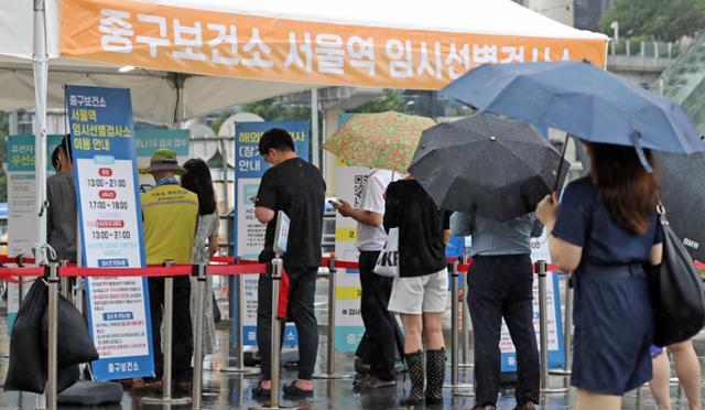 9일 오후 서울 중구 서울역에 설치된 코로나19 임시선별검사소에서 검사를 받으려는 시민들이 줄을 서고 있다. 뉴스1