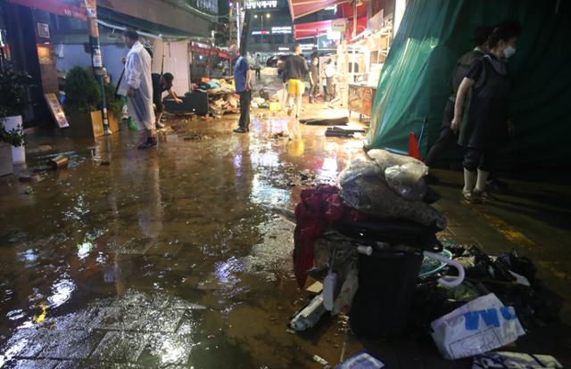 수도권에 폭우가 쏟아진 9일 새벽 서울 동작구 이수역 인근 남성사계시장에서 수해를 입은 상인들이 집기 등을 정리하고 있다. 뉴시스
