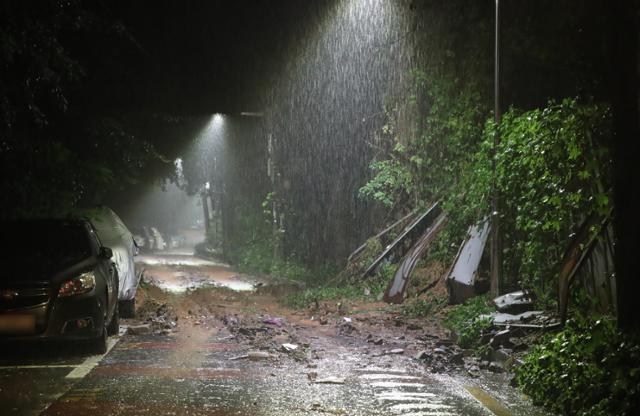 9일 새벽 서울 동작구의 한 도로에서 담벼락이 무너져 내려 토사가 유실되고 있다. 뉴시스
