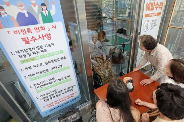 코로나19 재유행 우려로 요양병원·시설, 정신병원·시설의 대면 면회가 다시 제한된 지난달 25일 서울 마포구 시립서부노인전문요양센터에서 한 어르신이 가족들과 유리벽을 사이에 두고 비대면 면회를 하고 있다. 뉴스1