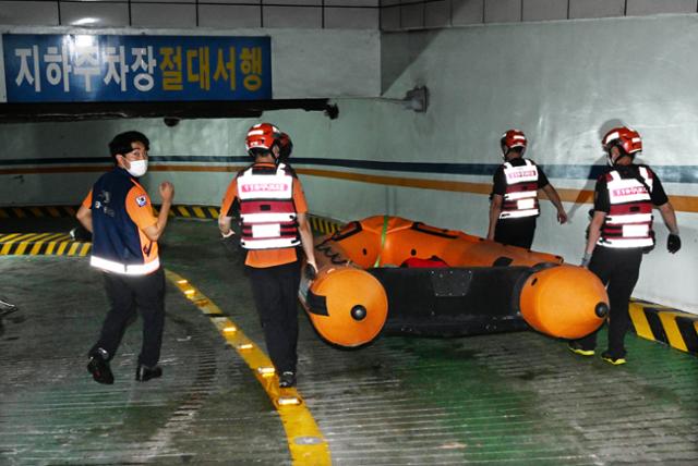 10일 서울 강남역 인근에서 119 특수구조대원들이 주황색 소방 구명보트를 들고 폭우로 휩쓸린 실종자들을 찾기 위해 강남빌딩 지하주차장 입구로 들어가고 있다 . 배우한 기자