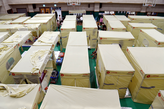 Flood victims from Guryong Village, a poor area in southern Seoul, take temporary shelter in a gymnasium at Guryong Middle School in Gangnam District, southern Seoul, on Wednesday. [YONHAP]