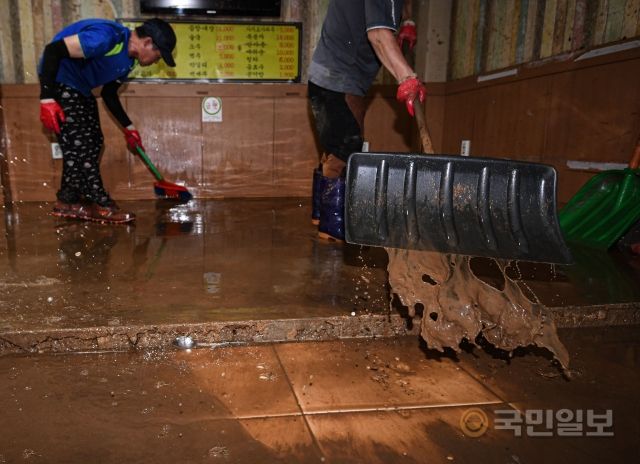 10일 서울 동작구 남성사계시장에서 상인들이 흙탕물을 빼내고 있다.
