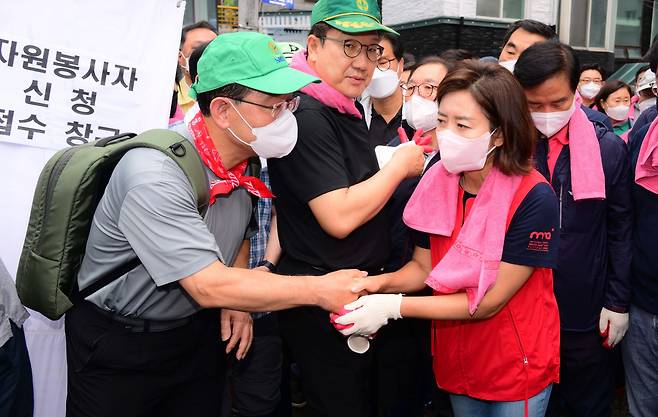 주호영 국민의힘 비상대책위원장(왼쪽)과 나경원 전 의원이 11일 폭우 피해를 입은 서울 동작구 사당2동 주민센터 앞에서 수해 복구 자원봉사에 앞서 인사하고 있다. /뉴스1