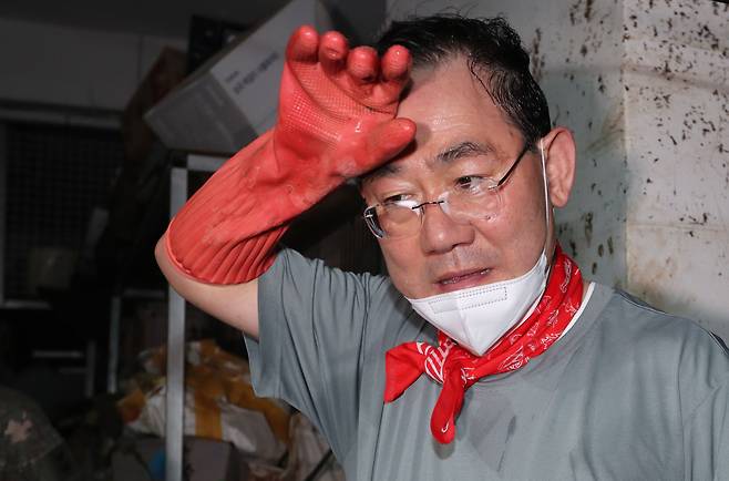 주호영 국민의힘 비상대책위원장이 11일 폭우 피해를 입은 서울 동작구 사당동의 한 빌딩 지하에서 수해 복구 자원봉사를 하며 땀을 닦고 있다. /뉴스1