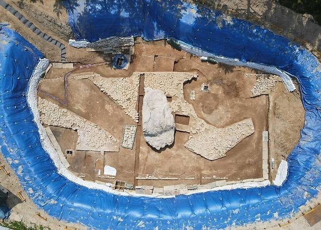 공중에서 내려다본 김해 구산동 지석묘 유적의 파괴 전 전경. 한가운데 있는 거대한 상석 주위 사방에 묘역의 핵심인 박석 수백여편들이 촘촘하게 깔린 모습을 볼 수 있다. 시 쪽의 정비업체는 이 박석들을 문화재청 협의 없이 무단으로 뽑아내 씻어내고 다시 박아넣는 정비 작업을 강행하며 원형을 뭉개버렸다. 김해시 제공