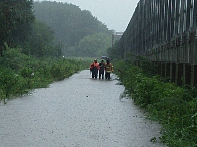 전북 군산 지역에 폭우가 쏟아진 11일 오전 군산시 미룡동 한 도로에서 시민이 소방당국의 도움을 침구 구역을 빠져나오고 있다. 전북소방본부 제공