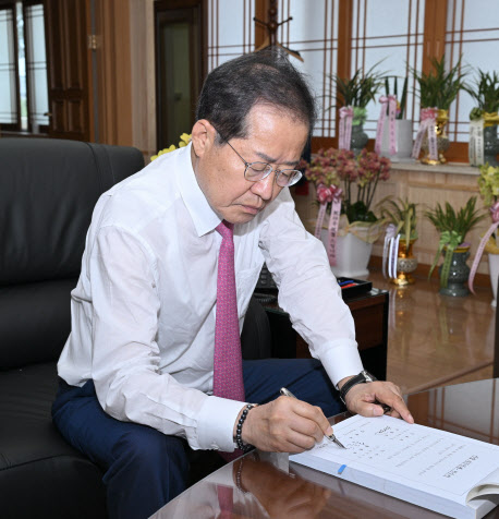 지난달 1일 취임한 홍준표 대구시장이 집무실에서 사무인수서에 서명하고 있다. (사진=대구시 제공)