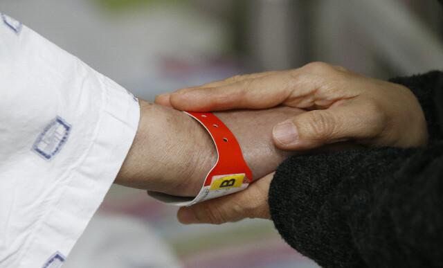 한 호스피스 병동에서 음악치료사가 말기암 환자의 손을 잡아주고 있다. <한겨레> 자료사진