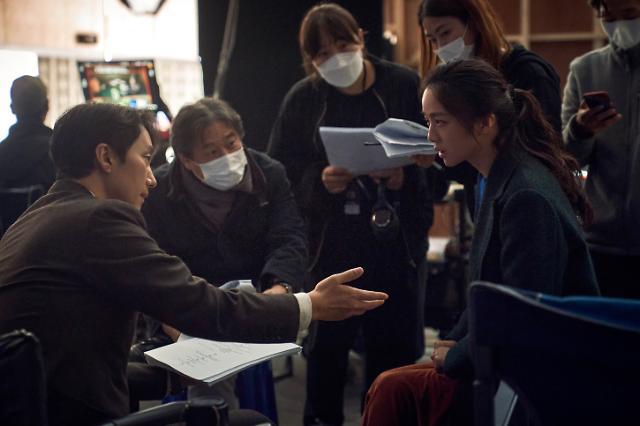 Director Park Chan-wook (center), actor Park Hae-il (left) and Tang Wei are seen on the set for “Decision to Leave.” (CJ ENM)