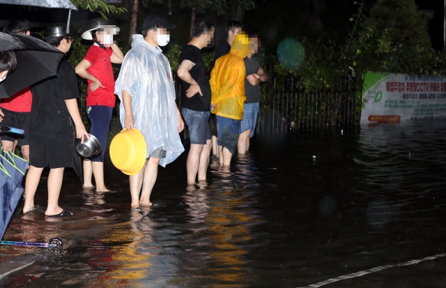 10일 충북 청주시 흥덕구 복대동의 한 아파트 앞 도로가 물에 잠겨 시민들이 큰 불편을 겪고 있다. 연합뉴스