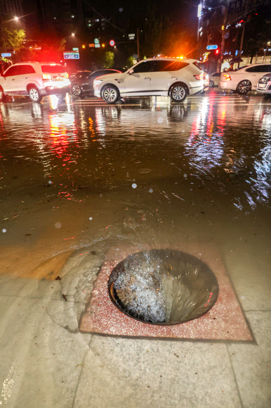 이틀째 폭우가 쏟아졌던 지난 9일 서울 강남구 대치사거리의 뚜껑이 사라진 맨홀 아래로 빗물이 빨려 들어가고 있다.연합뉴스