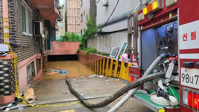 지난 8일 오후 9시 7분께 서울 관악구 부근 한 빌라 반지하에 폭우로 침수된 일가족 3명이 갇혀 신고했지만 결국 사망했다. 주민들에 따르면 사고가 난 빌라 바로 앞 싱크홀이 발생해 물이 급격하게 흘러들었고, 일가족이 고립돼 구조되지 못했다. 사진은 침수된 빌라 배수작업ⓒ연합뉴스