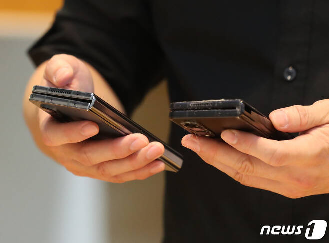11일 서울 서초구 삼성 딜라이트샵에서 한 시민이 삼성전자의 새로운 폴더블폰인 갤럭시Z플립4를 자신의 휴대폰과 비교해보고 있다. 2022.8.11/뉴스1 ⓒ News1 이성철 기자