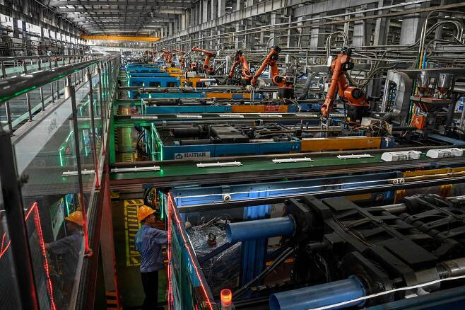 중국 광둥성 광저우시에 있는 가전회사 미데아 공장에서 근로자들이 로봇을 이용해 에어컨을 조립하고 있다. /AFP연합