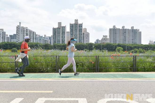서울 양천구 안양천 생태공원에서 시민들이 꽃이 활짝 핀 산책로를 달리고 있다.   사진=박효상 기자