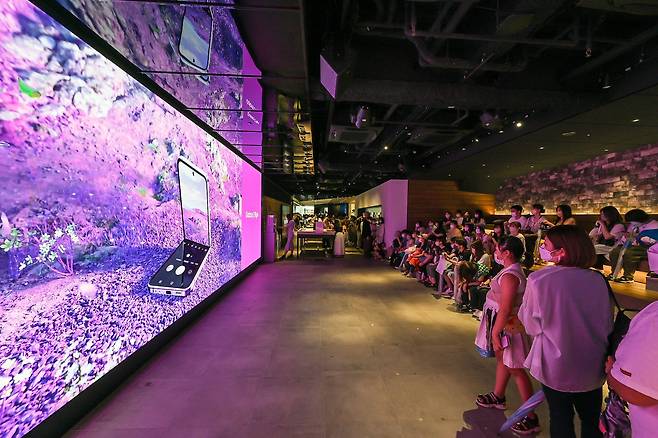 일본 도쿄의 갤럭시 하라주쿠(쇼케이스)에서 소비자들이 '갤럭시 Z 플립4 X BTS' 디지털 영상을 관람하고 있다. /삼성전자