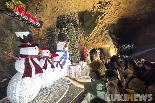 폭염경보가 발효된 14일 오후 울산 울주군 자수정 동굴나라를 찾은 관광객들이 동굴내부에 마련된 한 여름의 크리스마스무대에서 눈내리는 장면을 지켜보고 있다.