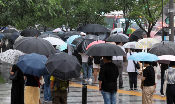 수도권 폭우가 계속된 지난 9일 오후 서울 종로구 세종로사거리 인근에서 퇴근길 시민들이 버스를 기다리고 있다. [사진 출처 = 연합뉴스]