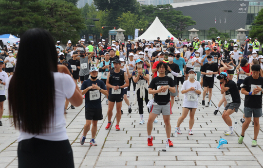 팔 돌리고 다리 굴리고…8km 달릴 결심 : ‘전국민 달리기’ 행사에 앞서 참가자들이 팔과 다리를 푸는 등 준비운동을 하고 있다. 뉴시스