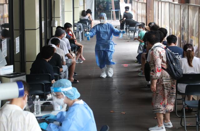 15일 서울 송파구보건소에 마련된 코로나19 선별진료소에서 의료진이 소독제를 뿌리고 있다. 뉴스1