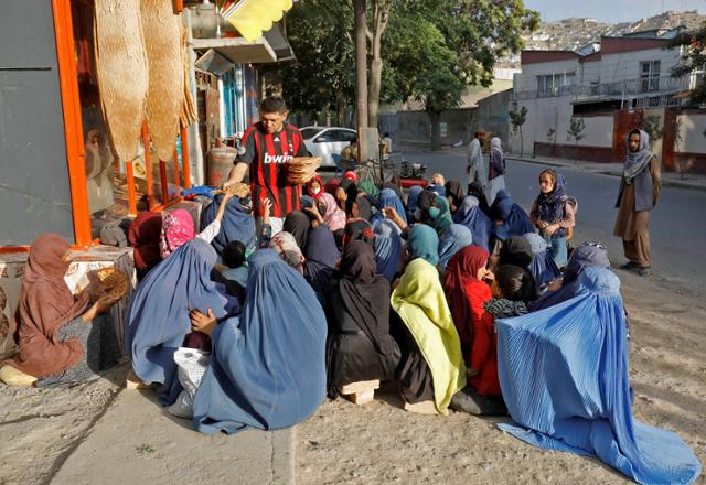 전신을 가리는 부르카를 착용한 아프간 여성들이 15일 수도 카불의 한 빵집에서 빵을 사기 위해 모여 있다. 카불=로이터 연합뉴스