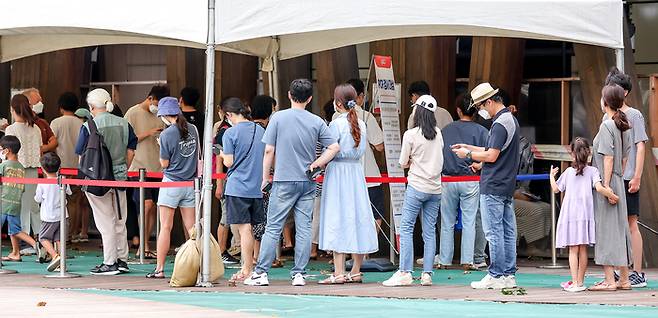 광복절인 15일 오전 서울 송파구보건소에 마련된 코로나19 임시선별진료소를 찾은 시민들이 줄을 서있다. 연합뉴스