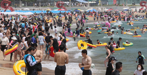 People pack Haeundae Beach in the southern city of Busan on Monday. [SONG BONG-GEUN]