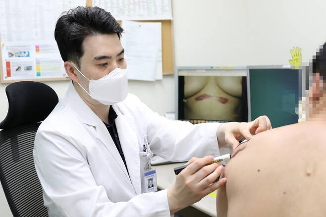 김충현 일산백병원 성형외과 교수가 켈로이드 환자의 상처 크기와 상태를 살펴보고 있다.