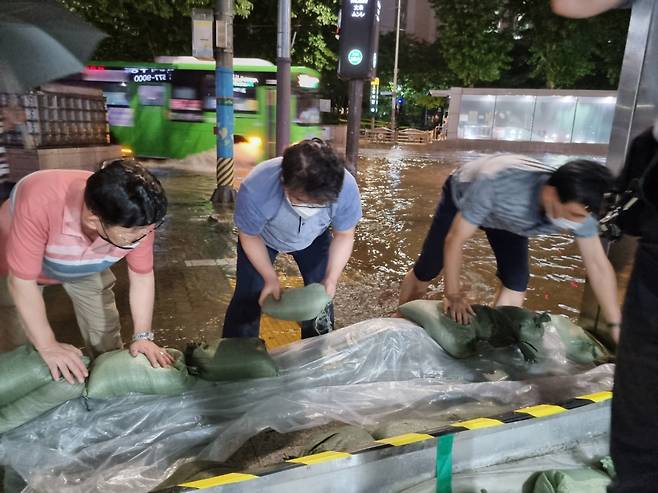 서울교통공사 관계자들이 빗물 유입을 막기 위해 모래주머니를 쌓고 있다. [서울교통공사 제공]