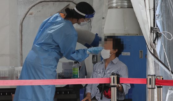 17일 부산진구 선별진료소에서 한 여성이 신종 코로나바이러스 감염증(코로나19) 검사를 받고 있다. 송봉근 기자