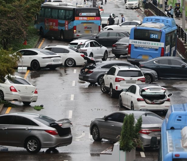 지난 9일 오전 서울 서초구 진흥아파트 앞 서초대로 일대에서 전날 내린 폭우에 침수됐던 차량이 모습을 드러내고 있다. 연합뉴스