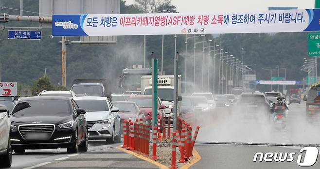 인천 강화군의 한 농가에서 국내에서 7번째로 아프리카돼지열병(ASF) 확진 판정이 난 26일 경기도 김포시에서 강화도로 가는 진입로에서 차량 방역작업이 실시되고 있다. 농림축산식품부는 지난 24일 정오에 전국에 발령됐던 돼지 일시이동중지명령 기간을 48시간 연장했다. 2019.9.26/뉴스1 ⓒ News1 이승배 기자