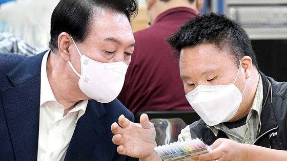 윤석열 대통령이 18일 서울 역삼동 충현복지관을 찾아 발달장애인들과 함께 색연필을 포장하며 이야기를 나누고 있다. 대통령실사진기자단