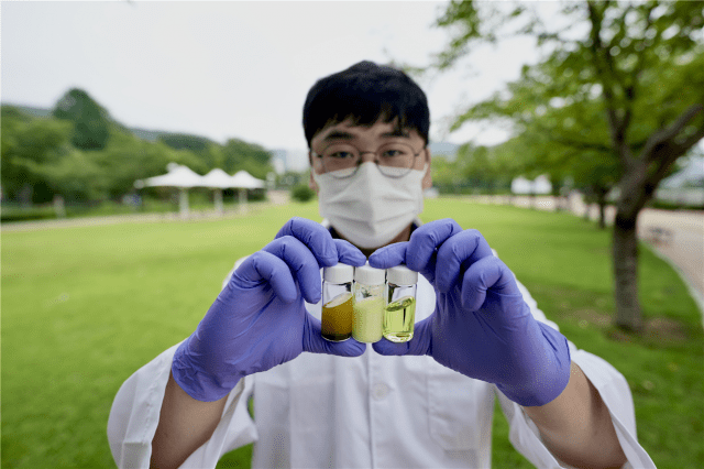 윤현성 UNIST 연구원이 에탄올 기반 페로브스카이트 용액을 손에 들고 있다. (자료=UNIST)