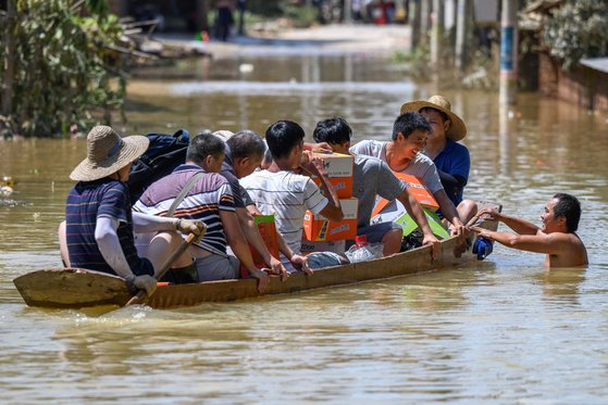지난 6월 23일 중국 남부 광둥성 칭위안시가 폭우로 침수되자 주민들이 배를 타고 대피하고 있다. AFP=연합뉴스