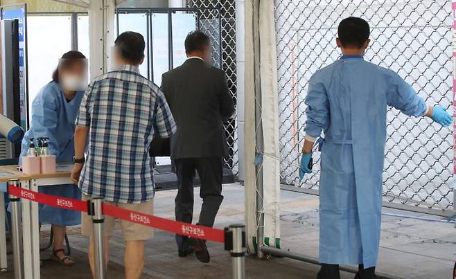 신규 확진자 수가 17만8,574명으로 집계된 18일 서울 용산구 코로나19 용산구보건소 선별검사소에서 시민들이 코로나19 검사를 위해 관계자의 안내를 받고 있다. ⓒ데일리안 김민호 기자