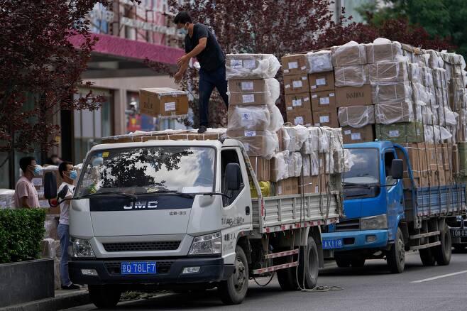 중국 베이징의 한 시장 앞에서 인부들이 상품 상자를 트럭에 싣고 있다.  / AP 연합뉴스